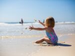 little girl throwing sand