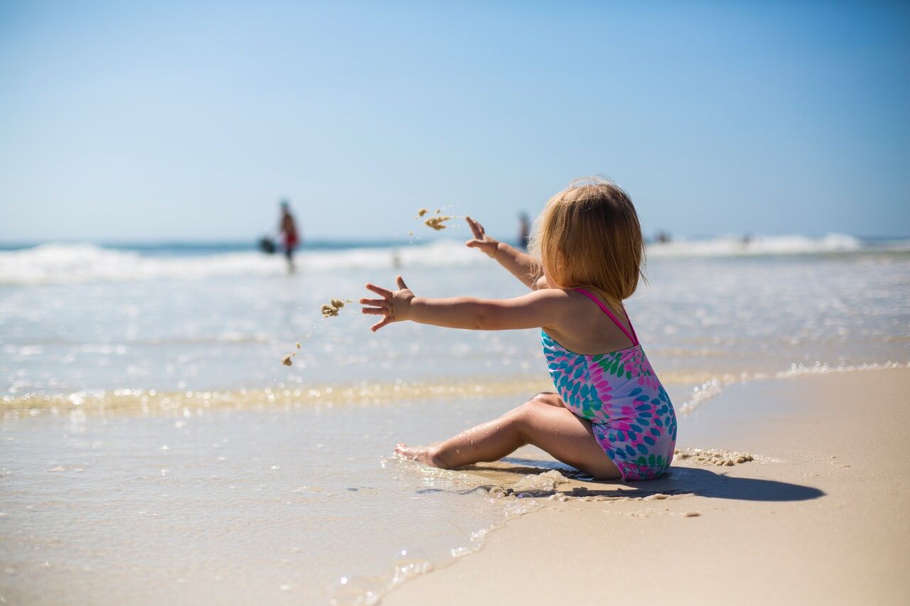 little girl throwing sand